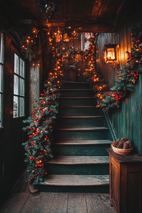 Transform your home with enchanting Christmas home decor. This beautifully lit stairway, adorned with festive garlands and pinecones, brings warmth and charm to any space. #ChristmasHomeDecor #FestiveStairs #HolidayLighting Christmas Stairwell, Christmas Stair Banister Decor, Xmas Staircase Decor, Christmas Hallway Ideas, Candles On Stairs Christmas, Staircase Christmas Decor Railings, Dark Academia Staircase, Festive Staircase, Fabric Garland Christmas Stairs