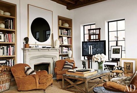 A large-scale work on paper by Richard Serra is given pride of place in the living area of a Manhattan apartment, where an LG flat-screen television is mounted on an artist's easel. A pair of Ralph Lauren Home club chairs and a vintage horn stool are grouped with a cocktail table by Lucca Antiques | archdigest.com Tv Room Design, New York City Apartment, New York Apartment, East Village, Rustic Living, City Apartment, Rustic Living Room, A Living Room, Ralph Lauren Home