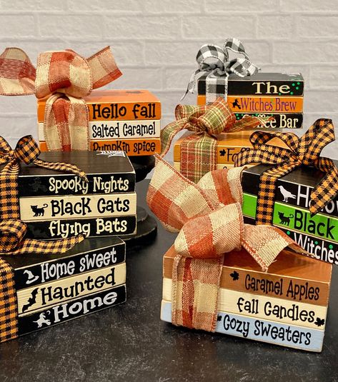 These fun book stacks will look beautiful with your holiday decor.  Made from wood and painted to look like books there is a festive ribbon tied around them and vinyl lettering on each book.  They are sealed with a poly coat sealant. Please choose your style from the drop down menu. Each book stack is approximately 5" x 3.5" x 2.25" Black pedestal in listings is not for sale.  You will receive book stack only. Each stack will come cellophane wrapped and is ready to ship. If you have any questions, please message me. Holiday Wood Books, Fall Stacked Books Diy, Fall Book Stack Diy, Christmas Wood Books, Fall Diy Crafts To Sell, Diy Wood Books, Halloween Tiered Tray Decor, Wood Books, Block Signs