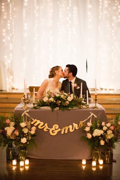 Set a romantic sweetheart table with beautiful flower arrangements and a twinkling backdrop. Wedding Couple Table, Reception Head Table, Winter Barn Weddings, Bride Groom Table, Girls Fun, Light Backdrop, Newly Married Couple, Wedding Table Decorations, Newly Married