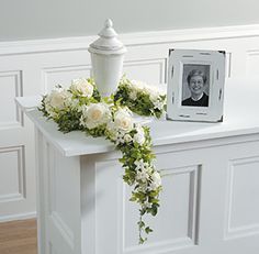 White rose flowers, urn, and matching photo frame memorial. Just one of 14 Funeral Urn Memorial Service Table Arrangement Ideas Cremation Urn Display, Urn Arrangements, Flower Urn, Sympathy Arrangements, Diy Arrangements, Memorial Flowers, Sympathy Flowers, Floral Garland, Table Arrangements