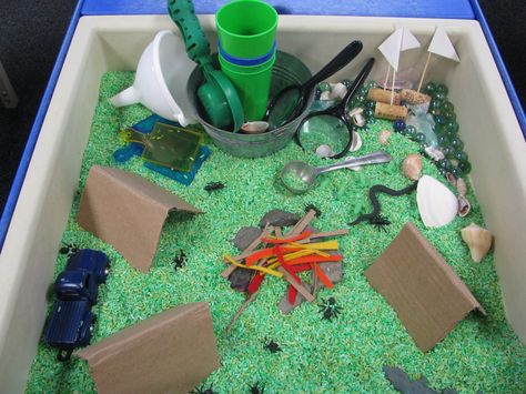 Camping Theme Sensory Table Green Rice blue marbles/lake cardboard tents, fire/cardboard, red and orange felt strips rocks, insects, boats Camping Theme Week Preschool, Camping Light Table Activities, Sensory Camping Activities, Montessori Camping Theme, Reggio Camping Theme, Camp Sensory Bin, Camping Sensory Table, Dramatic Play Camping Theme, Camping Theme Sensory Bin