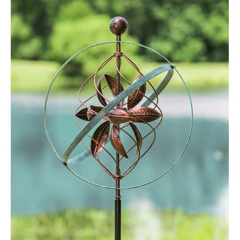 Our Bronze and Patina Spiral Metal Wind Spinner is beautiful enough for even the most formal sculpture garden. Treated with copper-colored and antiqued patina-like finishes this unique spinner resembles some kind of ancient nautical or astronomical instrument. The dual outer rings bear the bluish color of a patina while the inner spiral and cupped leaves have a weathered copper color. Sturdy stakes ensure secure installation in your garden. Large Garden Art, Green Energy Design, Animated Garden, Minimalist Landscaping, Kinetic Wind Spinners, Pool Plants, Invincible Summer, Garden Wind Spinners, Garden Spinners