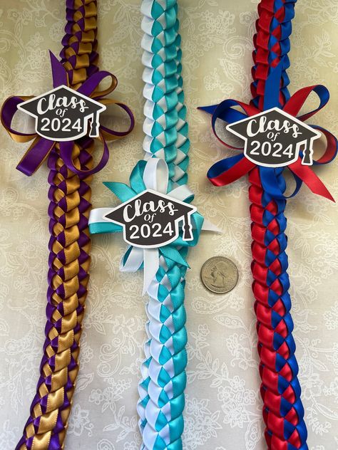 Width: 1 inch Length: 38 inches  Made from 3/8" ribbon Larger 5/8" Version here:  https://808jemcreationsllc.etsy.com/listing/1736972433 This lei is slightly different from my other single braided listings. This one has a bow with added ribbon surrounding it and the class of 2024 will be placed on top. The graduation caps are made from cardstock.  You can choose up to 2 colors (See photo for color options) and every lei will come with the graduation cap already on them. I hot glue the caps direc Ribbon Graduation, Graduation Leis Diy Ribbons, Graduation Leis Diy, Pink Notepad, Diy Graduation Gifts, Custom Graduation Gift, Graduation Candy, Diy Graduation, Graduation Leis