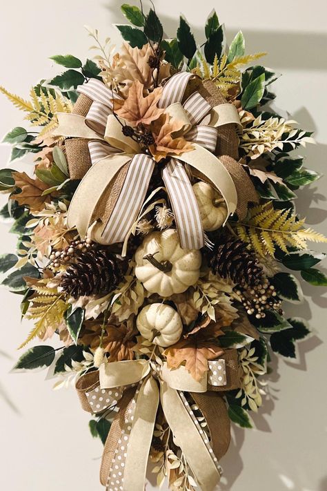 PURCHASE: 30-inch Taupe Faux Pine Everyday Fall  Wreath! Click the ADD TO CART button on the right and follow the prompts. A shipping notification will be emailed to you as soon as it is shipped. DESCRIPTION: Taupe 30-inch Faux Pine Wreath Base; Cream Pumkins, Pine Cones/Fall Bush  Cream/Tan Fall Leaves; Beautiful Triple Layered Bows and Ribbon Tails; Greenery: Rosemary Picks, Lambs Ear, Cream Floral Stems, etc. Green with white tips Ficus Stems Deco Mesh Curls Dimensions: Tip to Tip; 37 L, 23 W Fall Swag Wreath, Fall Outdoor Light Swags, Thanksgiving Swag Wreath, Table Fall Decor, Farmhouse Swag, Front Door Decorations, Leopard Print Fall Wreath, Cheetah Print Fall Wreath, Front Door Swag