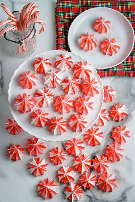 This Christmas season enjoy these delicate peppermint meringue cookies with candy cane flavor and looks! These gorgeous red striped cookies melt in your mouth and are the perfect treat for your holiday party. Candy Cane Meringue Cookies, Spiced Meringue Cookies, Peppermint Meringues Recipe, Peppermint Meringue Kisses, Candy Cane Meringues, Christmas Mirangue, Mint Meringue Cookies, Christmas Dessert Peppermint, Meringue Cookie Designs