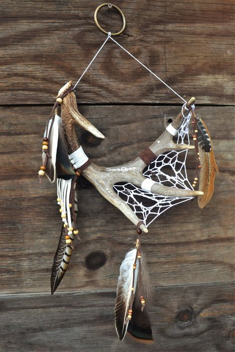 This dreamcatcher is one of a kind, handcrafted using naturally shed deer antler. The feathers are turkey and duck, and they hang from leather cord. All beads are made from wood. Holes were drilled into back of antler to run webbing through. The designs on the antler were carved and then painted. Webbing is made from cotton cord. It all hangs from a brass ring with cotton cord. This dreamcatcher would make a wonderful gift idea!  Antler approx. dimensions 6"x9.5"x12" Total approx. length 24" Total approx. width 10.5" Antler Crafts Diy, Bone Decor, Diy Antler Projects, Antler Decor, Elk Antler Decor, Deer Antler Crafts Diy, Macrame With Deer Antlers, Deer Horn Ideas, Deer Antler Art