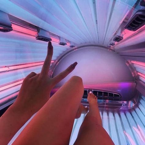 Woman laying on a sunbed with pink and blue lamps. You can see tanned legs and a peace sign on a manicured hand Sunbed Tanning Tips, Solarium Tanning, Tanning Goals, Sunbed Tanning, Tanning Quotes, Summer Prep, Lilo And Stitch Quotes, Holiday Prep, Tanning Tips