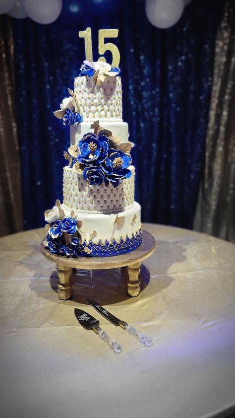 Blue Quinceanera Hairstyles, Navy Blue And Gold Quince Cake, Quince Royal Blue Cake, Dark Blue Quinceanera Cake, Blue With Gold Quinceanera Dresses, Quince Decorations Blue And Gold, Royal Blue And Gold Cake Quinceanera, Navy Blue And Gold Sweet 16 Theme, Royal Blue And Gold Quince Cake