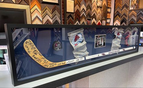 ❤️🏒💙 Custom framed team signed Colorado Avalanche hockey stick with banners, puck, photos and tickets! Framed with linen backing, UV acrylic and frame by AMPF Moulding! #art #denver #colorado #pictureframing #customframing #5280customframing #jerseyframing #sportsframing #avalanche #nhl #stanleycup #shadowbox Hockey Stick Display Ideas, Hockey Shadow Box Ideas, How To Display Hockey Pucks, Hockey Puck Shelf, Sports Man Cave, Colorado Avalanche Hockey, Hockey Cards Collection, Framed Jersey, Colorado Avalanche