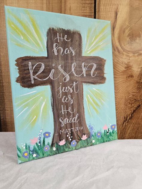 "Decorate for easter with this beautiful reminder of the resurrection! A floral outside scene of the cross with \"He has Risen just as he said - Matt. 28:6\" is handlettered in white ink.  There are two size options: #1 Dimensions: H: 10 in W: 10 in #2 Dimensions: H: 10 in W: 8 in" Easter Ideas For Kids Crafts, Easy Easter Painting Ideas, Painting Ideas Christian Easy, Easter Cross Decor, Cute Easter Paintings, Cute Christian Painting Ideas, Easy Easter Paintings On Canvas, Easter Painting For Kids, Cute Christian Paintings On Canvas Easy