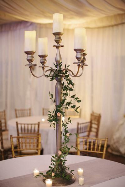 Tall Candelabrum | Bright lights and beautiful. Adding a centerpiece to a table immediately makes it look sophisticated, complete, and beautiful. Floral centerpieces are the usual go-to if you want to dress up your tablescape, but candles are an easy and elegant centerpiece feature that could save you money, too. There are countless gorgeous ways to make a candle centerpiece, and we’ve found some of the best. Candles look dreamy and romantic, especially surrounded by a wreath of flowers or Tiered Candle Centerpiece, Candelabra Flowers, Candelabra Wedding Centerpieces, Candles And Flowers, Vintage Wedding Centerpieces, Candelabra Wedding, Candlestick Centerpiece, Floating Candle Centerpieces, Tall Candlesticks