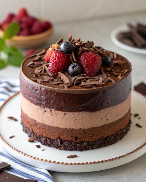 🍫🍰 Triple Chocolate Mousse Cake: A Decadent Dessert for Chocolate Lovers! ✨  This Triple Chocolate Mousse Cake is a show-stopping dessert with layers of rich, creamy mousse in dark, milk, and white chocolate. It’s light, airy, and utterly indulgent—perfect for special occasions or when you need a chocolate fix! Let’s dive in! 🍴💛  🥘 Ingredients: For the Dark Chocolate Layer: 🍫 4 oz dark chocolate (70% cocoa), chopped 🥛 1/2 cup heavy cream 🥚 2 large eggs, separated 🍯 2 tbsp sugar  For the Milk ... Triple Chocolate Mousse, Triple Chocolate Mousse Cake, Beautiful Cake Designs, Chocolate Mousse Cake, Triple Chocolate, Beautiful Cake, Mousse Cake, Chocolate Mousse, Sweet Cakes