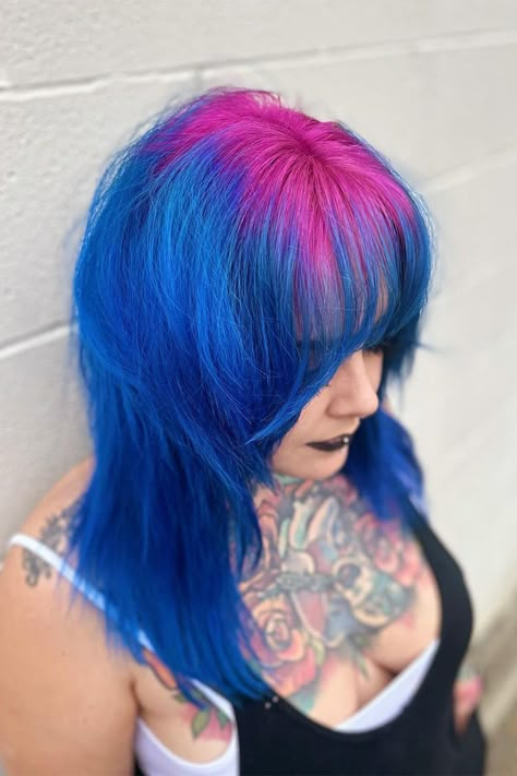 Witness the striking combination of bright pink roots and blue hair with bangs on the right side of this person's head! 💖💙 Embrace your adventurous side and make a statement with this eye-catching hairstyle. Ready to stand out from the crowd? Book your appointment now and let's create your own unique look! #BrightPinkRoots #BlueBangs #ColorfulHair #HairInspiration #BookNow #HairMagic Roots Different Color Hair, Unique Vivid Hair Color, Blue Hair Pink Bangs, Blue Hair With Pink Tips, Hair Dye Ideas Bright, Pink And Blue Hair Dye Ideas, Hair Color Ideas Crazy, Blue Hair Pink Tips, Purple Roots Blue Hair