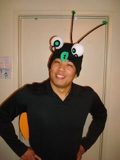 Easy bug costume. She started with a plain black beanie and added styrofoam ball eyes and pipe cleaner antennae with little green pom poms on the end.  Also made insect wings. Otherwise dressed in black.  Cute simple idea that gives the person a lot of freedom and mobility. Adult Bug Costume Diy, Bug Costume Diy, Bee Costume Diy, Bug Costumes, Fly Costume, Firefly Costume, Adult Princess Costume, Homemade Mermaid Costumes, Native American Halloween Costume