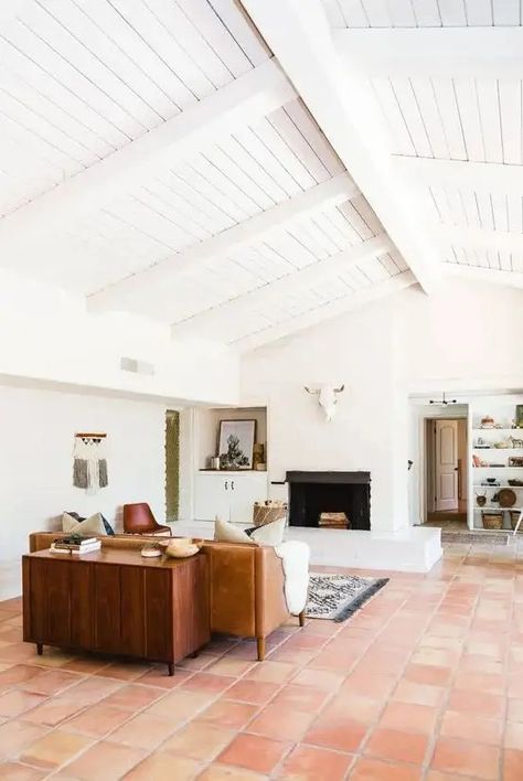 a mid century modern living room with white walls and a ceiling, a terracotta tile floor, a leather sofa, a stained cabinet and a fireplace Terracotta Floor Living Room, Terracotta Tile Floor, Minimalist Decor Ideas, Tile Floor Living Room, Saltillo Tile, Desert House, Mexican Tiles, Terracotta Tile, Living Room Tiles