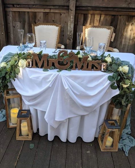 Sweetheart Table Wedding Flowers Simple, Wedding Arbor Behind Sweetheart Table, Mrs And Mr Wedding Table, Rustic Bridal Table Ideas, Bride And Groom Table Decorations Simple, Couples Wedding Table Ideas, Rustic Sweetheart Table Decor, Rustic Wedding Sweetheart Table Ideas, Sage Green Sweetheart Table