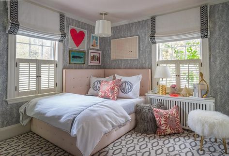 A pink tufted cover headboard sits beneath gallery art hung from a wall covered in black and white print wallpaper lit by a Barbara Barry Simple Scallop Pendant hung from a light pink ceiling over a pink bed dressed in white and gray monogrammed bedding. Bed Under Window No Headboard, Simple Girls Bedroom, Liz Caan, Corner Headboard, Corner Bedroom, Instagram Corner, Corner Bed, Pink Headboard, Bed In Corner