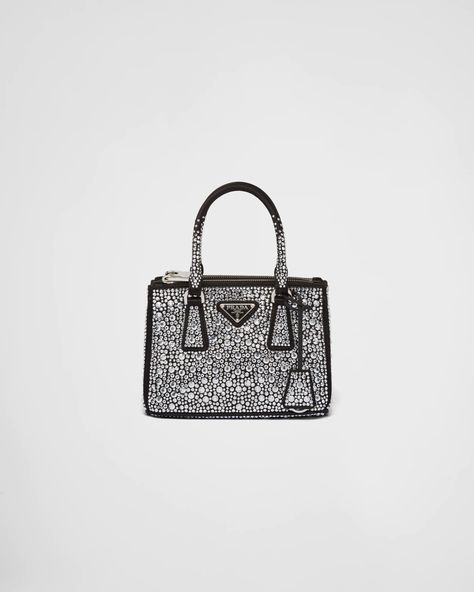 A surface of dazzling crystals in various sizes creates a precious play of sparkles and glimmers on this Prada Galleria bag, recalling the jewelry world. The accessory, which exemplifies the centennial excellence of Prada in luxury leather goods, becomes a reflection of the brand's modernity and stylistic identity that seeks to interpret kaleidoscopic contemporaneity through a pragmatic design and structured lines. Presented in a mini version, the bag is made of fine silk satin. The Prada Galler Prada Nylon Mini Bag, Prada Galleria Bag, Galleria Vittorio Emanuele Ii, Prada Mini, Prada Galleria, Hand Bags For Women, Luxury Purses, Fancy Bags, Womens Purses