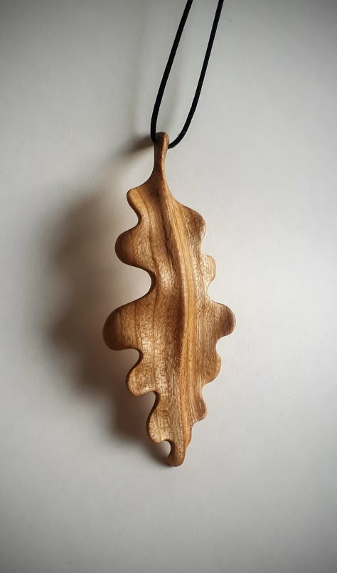 Enhance your style with the timeless beauty of nature captured in this stunning hand carved oak leaf pendant. Meticulously crafted from rich cherry wood, this unique piece of jewelry is a true work of art that will add a touch of elegance and charm to any outfit. Natural Finish: Pendant has been finished with a smooth, glossy surface and protected with linseed oil and beeswax  enhancing its natural beauty and highlighting the warmth of the wood. cherry wood, oak leaf, wooden pendant, nature Wood Carving Pendant, Wooden Jewelry Handmade, Wood Jewerly, Wood Charms, Wood Necklace Pendant, Unique Wood Carving, Nature Themed Gifts, Wood Jewelry Diy, Oak Leaf Necklace