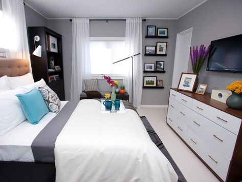 A bench by the window takes the place of a built-in window seat in this cool gray bedroom. A bookshelf with a light for reading and a TV in front of the bed make this space the perfect getaway. Tv In Front Of Bed, Bedroom With Tv Ideas, Bedroom With Tv, Built In Window Seat, Bedroom Decor For Women, Tv Ideas, Floating Shelves Bedroom, Contemporary Bedrooms, Gray Walls