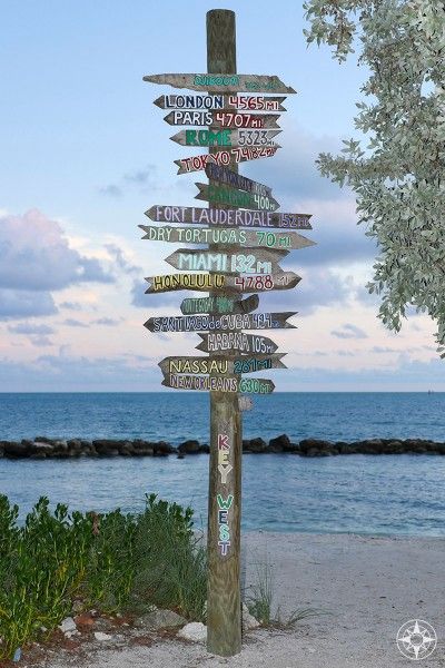 The iconic destination sign post pointing from Key West all over the world - at dusk on the beach in Fort Taylor Park. #HappierPlace #travel #travelinspiration Destination Signs, Tiki Signs, Travel Key West, Zachary Taylor, Florida State Parks, Backyard Games, Key West Florida, Sign Post, Beach Rentals