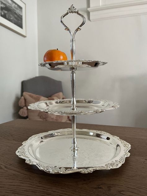 Just the thing for party season! With its romantic pattern, this 3-tier server is ready to add vintage charm to special occasions--from the holidays to showers, teas and garden parties. This made-in-China silver-plated tray features ornate details, an engraved pattern on each tier, scrolling, a shiny silverplated finish, and like-new condition. #threetier #cakestand #teastand #showers #wedding #afternoontea #downtonabbeystyle #regency #vintagewedding #silver #silverplated #3tier #tidbittray 3 Tier Server, Dining Display, Tea Stand, Dish Collection, Romantic Pattern, Tiered Server, Downton Abbey Fashion, Silver Platters, Cake Tray