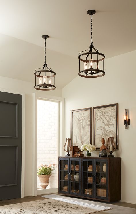 The rustic and farmhouse style Brenham foyer lights add warmth to the entryway interior design of this lovely home. Hand-painted weathered gray faux wood accent rings bookend the top and bottom of the light fixture. A black metal frame with simple metal bars and ribbon-like metal arms reach down from a central metal link chain. #foyer #entryway #interiordesign #homedecor #home #decor #warm #warmth #lighting #light #farmhouse #rustic #modernfarmhouse #farmhousestyle #rustichome #rusticdesign Foyer Lights, Farmhouse Foyer, Entryway Light Fixtures, Foyer Lighting Fixtures, Entry Lighting, Home Office Inspiration, Entryway Lighting, Foyer Lighting, Outdoor Hanging Lanterns