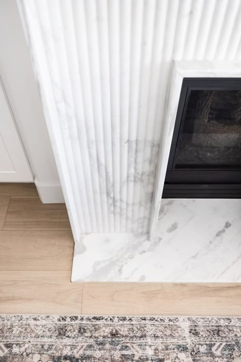 Portfolio | Maya Axt Interiors Fluted Marble Fireplace Surround, Fluted Tile Fireplace, Fluted Fireplace, Black And White Beach House, Stone Tile Fireplace, Fluted Marble, College Furniture, Marble Fireplace Surround, Wood Mantle