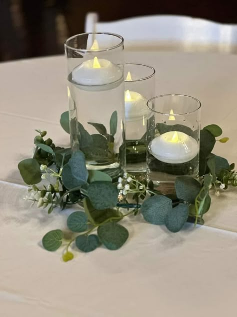 Greenery On Circle Table, Simple Green Wedding Centerpieces, Greenery Centerpiece Wedding Round Table, Round Eucalyptus Centerpiece, 3 Vase Centerpiece Ideas, January Wedding Centerpieces, Whimsical Wedding Table Decor, Simple Centerpiece Wedding Round Tables, Round Table Centrepiece