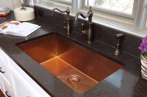 The copper sink is a great contrast in this all white kitchen with black countertops. Copper Sink Black Countertop, Copper Farmhouse Sink Black Countertop, Black And Copper Countertops, Black White And Copper Kitchen, Dark Japandi, Copper Countertops, Slate Countertop, Black Kitchen Countertops, Dark Counters