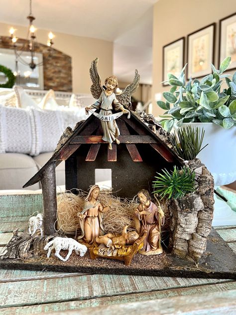 Nativity Scene On Side Table, Christmas Nativity Set Stand, Nativity Scene Decor Ideas, Nativity Set On Piano, Nativity Set Display Ideas, Nativity Sets Display, White Nativity Set, Pictur Behind Nativity Sets, Nativity Set Angel