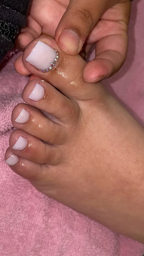 White Pedicure Toenails Rhinestone, Rhinestone Toenails Designs White, Milky White Gel Pedicure, White Pedicure Designs Toenails, Prom Toes Toenails, White Sparkle Toe Nails, Graduation Toe Nails, Nut White Nails With Design, Acrylic Toenails White