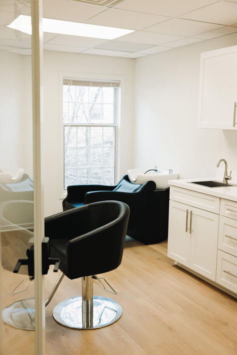 A space with a black salon chair and shampoo system surrounded by white walls and cabinetry. Backyard Salon, Minerva Beauty, Salon Pictures, Baby Taylor, Hair Salon Decor, Suite Life, Beauty Salon Decor, Salon Interior Design, Salon Equipment