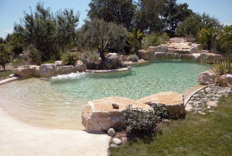 lagoon beach pool- add more tropical plants around, CHLORINE-FREE WATER FILTRATION, UNDERWATER LIGHTS, INTEGRATED WHIRLPOOLS, CASCADES, CURRENT STREAMS, UNDERWATER MUSIC SYSTEMS, WATERFALL AND A SPECIAL FLOOR AND SIDE WALL SURFACE APPLICATION WHICH IS NATURAL SAND BASED TO ACHIEVE THE UNIQUE BEAUTIFUL ORGANIC "BEACH" LOOKING ATMOSPHERE. Underwater Music, Swimming Pool Pond, Beach Entry Pool, Building A Swimming Pool, Natural Swimming Ponds, Pool Finishes, Lagoon Pool, Backyard Beach, Swimming Pond