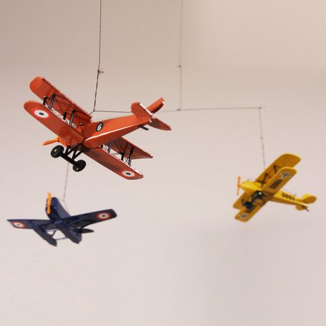 This four colored airplane flying mobile is a handmade wooden aircraft décor made of solid wood. The miniature toy airplanes are authentic wooden biplane and seaplane replicas from the 1920s making it a perfect hanging aviation ceiling decor. Each vintage model airplane in the hanging mobile is hand-painted. There is one of each color airplane model - red, green, blue, and yellow.This 3D airplane mobile is a great décor for your office as well as a great nursery mobile in a kid's playroom. It mo Boys Airplane Bedroom, Airplane Nursery Theme, Airplane Kids Room, Airplane Room Decor, Airplane Bedroom, Airplane Boys Room, Vintage Playroom, Vintage Boys Room, Vintage Travel Decor