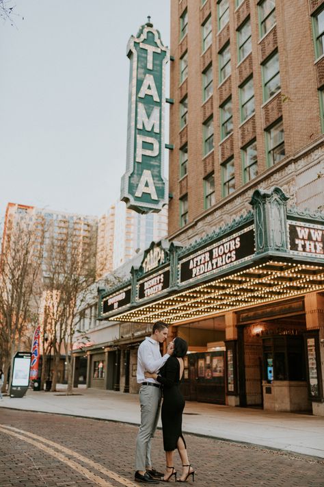 Bride in all black standing with groom in front of tampa theater sign Downtown Rooftop Engagement Photos, Downtown Tampa Elopement, Hyde Park Tampa Photoshoot, In Town Photoshoot, Tampa Theatre Photoshoot, Couples Photo Shoot Downtown, Down Town Photoshoot Couples, Editorial Downtown Engagement Photos, Downtown Tampa Photoshoot