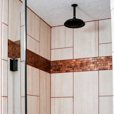 This shower's copper backsplash and grout paired with light vertical tile and rubbed bronze fixtures complimented the existing cabinet. #shower #bathroomremodel #copper #tile #grout #rubbedbronze Copper Tile Shower Ideas, Copper Grout, Vertical Tile, Bathroom Family, Shower Modern, Copper Backsplash, Copper Tiles, Bronze Fixtures, Master Shower