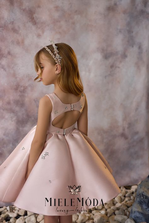 The Blossom Grace flower girl and party dress is a charming fusion of elegance and playful sophistication, designed to make every little girl feel like a blossoming ballerina. The fitted bodice, featuring a chic square neckline, is crafted from the finest Mikado fabric, offering a smooth, luxurious feel. Embellished with hand-stitched beadwork in floral patterns, the dress sparkles with delicate beauty, while the knee-length, full circle tulle skirt adds a voluminous and whimsical touch. The pla Corset Dress Ideas, Pink Dress Kids, Alexandrina Dresses, Kids Gowns, Birthday Gowns, Baby Princess Dress, Kids Christmas Dress, Kids Frock, Frocks For Kids