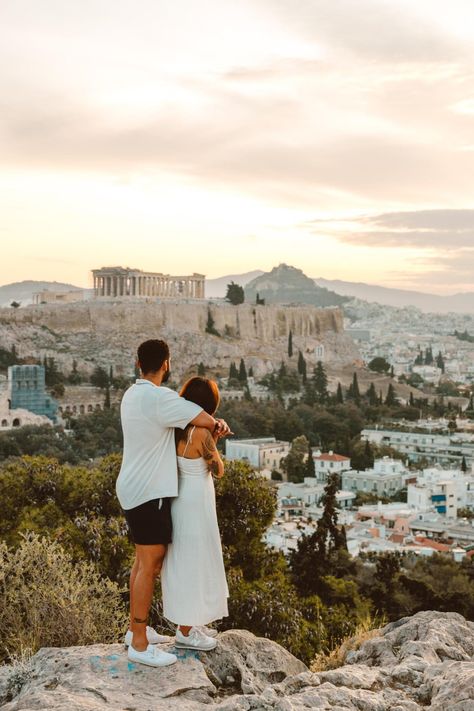 a couple hold hands on Philopoppus Hill, watching the sun rise over the Acropolis and the city of Athens, Greece. Athens Couple Photos, Greece Pics, Athens City, Italy Honeymoon, The Acropolis, Sun Rising, Anniversary Trips, Acropolis, Athens Greece