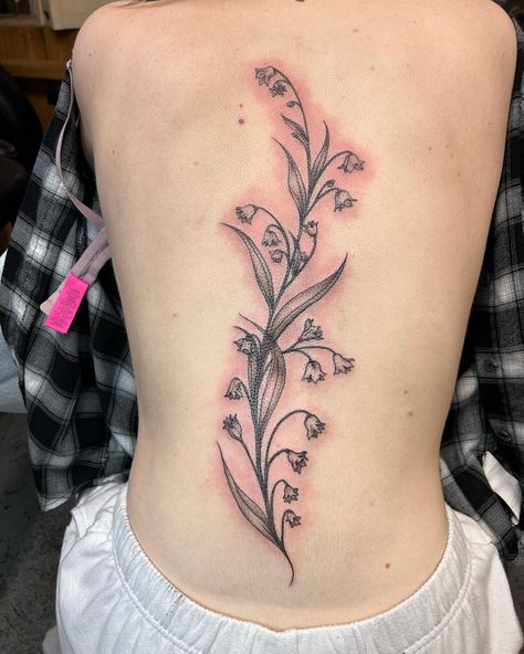 Delicate fine line spine tattoo done by @colleenajsmith! The beautiful flowers look so good in that perfect spot!! 😍⁠ ⁠ "She’s a little spicy looking, but here is an organic free flowing spinal tattoo that is comprised entirely of Lilies of the Valley. A healing flower which in the Ancient Roman tradition, had magical healing properties and the power to incant the spirits of those past beyond." - Colleen⁠ Spine Tattoos Lily Of The Valley, Tattoo Ideas Lily Of The Valley, Spine Tattoo Traditional, Flower Spinal Tattoo, Lily Of The Valley Back Tattoo, Lily Of The Valley Spine Tattoo, Lily Spine Tattoo, Nature Spine Tattoo, Line Spine Tattoo