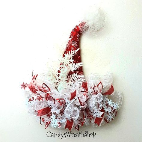 This Santa Hat hanging will highlight your Christmas decor.  The hat brim is White snowball decomesh ruffles and loaded with snowflake ribbons, felt snowflake ribbon, glitter fern, glitter curls, and wood snowflake pick.  The hat frame is wrapped with Christmas snowflake fabric mesh, and a glitter tulle topper completes it. It is approximately 23" tall, 20" wide and 6" deep.  It is already made and ready to ship.  The wreath pictured is the exact one that will be shipped. Check out my other wrea Santa Hat Door Hanger, Santa Hat Wreath, Cross Wreaths, Snowflake Fabric, Snowflake Ribbon, Santa Claus Wreath, Dt Crafts, Wing Angel, Christmas Door Hangings