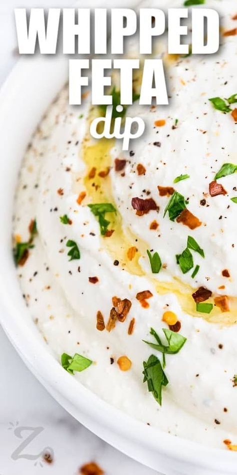 This recipe for whipped feta dip is delicious and ready to serve in minutes. Just blend feta cheese with Greek yogurt, olive oil, garlic, and hot pepper. Garnish with fresh parsley and enjoy! This versatile feta dip can be sweetened with a swirl of honey, or cranberry sauce. Or, dress it up with chopped olives, tomatoes, or pistachios. #whippedfetadip #ourzestylife #whippedfetadipgreekyogurt #whippedfetadipwithhoney Easy Whipped Feta Dip, Appetizer Recipes Whipped Feta, Whipped Feta Dip With Honey, Whipped Feta And Roasted Red Pepper Dip, Feisty Feta Dip, Feta Cheese Dip, Whipped Feta Dip, Dip Ideas, Greek Yogurt Dips