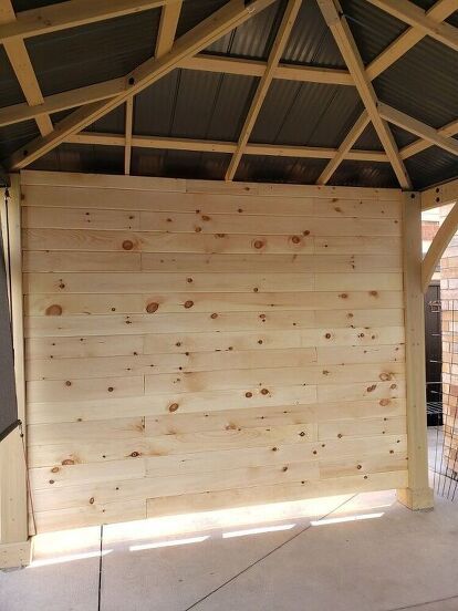 I added a privacy wall/ T.V. to our gazebo by framing up one side of the gazebo and adding pine tongue and groove to the inside. Not only does it create privacy but it's the perfect place for mounting a t.v. , hiding the not so pretty part of our backyard behind it, and blocking the strong winds we get....and it gives the gazebo a cozy feel.Although there are many other ways we could've done this wall, we did it this way for our home, weather and purpose. And we love it. It's getting a… Privacy Gazebo Ideas, Outdoor Patio Tv Wall Ideas, Patio Privacy Wall Ideas, Privacy Wall Ideas, Patio Privacy Wall, Porch Tv, Gazebo Bar, Gazebo Side Panels, Gazebo Privacy