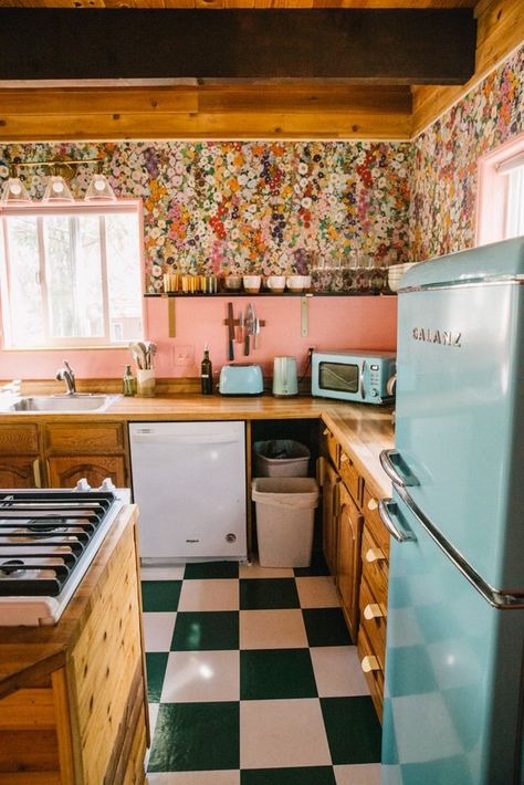 My pink kitchen makeover - from drape to colorful and all without a major renovation! I loved my retro kitchen and turned it into a cool pink kitchen with floral wallpaper. I kept my wood cabinets instead of doing pink cabinets but did pink walls and pink floral wallpaper. It was cheaper to not do pink subway tiles and instead use paint and retro appliances to add color to my shabby pink kitchen. 70s Pink Kitchen, Pink And Wood Kitchen, Floral Backsplash Kitchen, Pink Backsplash Kitchen, Pink And Yellow Kitchen, Southwest Kitchen Ideas, Pink And Green Kitchen, Pink Kitchen Walls, Pink Kitchen Cabinets