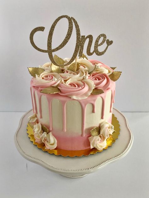 Pink to white gradient cake. Pink drip. Rosettes act as roses and there are gold leaves made from gum paste. In the middle there is a gold and sparkly cake topper that says “One”. Pink And Rose Gold Cake, Cake For One Year Old, Pink Drip Cake, Birthday Cake Roses, One Year Old Birthday, 10 Cake, Rose Gold Cake, Gold Birthday Cake, One Cake Topper