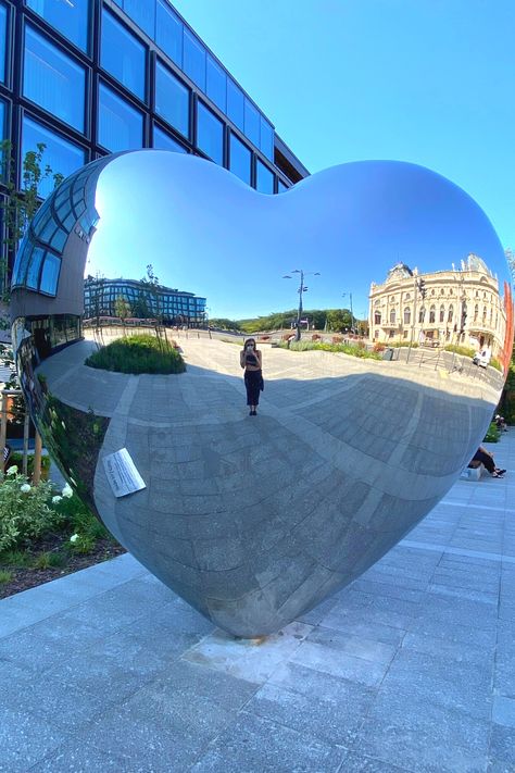 Take a picture of yourself or with a friend in this heart shaped mirror in Łódź, Poland. After a shopping day in the Manufaktura, you can walk to the heart, take a picture and continue to Piotrkoska Street. There you can chose from numerous great restaurants and grab a bite to eat. Exact Location: Plac Wielkiej Orkiestry Świątecznej Pomocy Poland Summer, Heart Shaped Mirror, Lodz Poland, Shaped Mirror, Travel Recommendations, Lodz, Take A Picture, Great Restaurants, Shopping Day