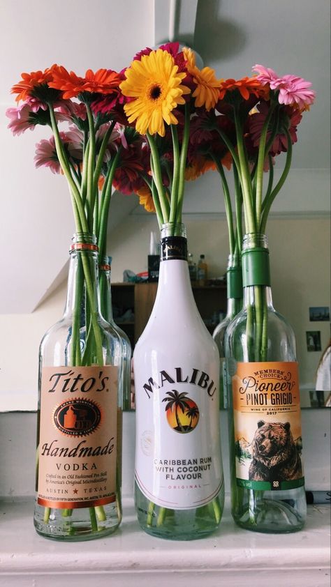 Bright Flowers in Bottles College House Ideas, Flowers In Bottles, Alcohol Bottle Decorations, College House Decor, Girl Apartment Decor, Be Aesthetic, Hangout Room, College Room Decor, College House