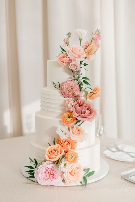 four tiered wedding cake adorned with peach and pink florals and greenery Peach Wedding Cake Simple, Peach Fruit Wedding, Wedding Cake Pink And Orange, Peach Flower Wedding Cake, Pink Peach Wedding Theme, Spring Floral Wedding Cake, Wedding Cake Peach Flowers, Teal Peach Wedding, Wedding Cake Pastel