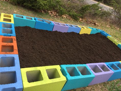 Spray painted cinder blocks. Inside each hole is herbs. Vegetables will go in middle section. Kindergarden Yard Ideas, Painted Cinder Blocks, Painted Cement Blocks, Painted Cinder Block Garden, Garden Beds Cinder Blocks, Backyard Cinder Block Wall Painting Ideas, Interactive Children’s Garden, Diy Kids Playground, Kids Backyard Playground